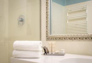 a bathroom with a sink and a mirror and towels at Hotel Palazzo Vitturi in Venice