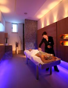 uma mulher ao lado de uma cama num quarto em Secret Forest - Wellness Retreat & Healing Spa em Miliou