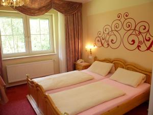 a bedroom with two beds and two windows at Historisches Landhotel Studentenmuehle in Nomborn