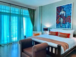 a bedroom with a large bed with a painting on the wall at Casa Blanca Boutique Hotel - SHA Plus in Phuket Town +108 photos