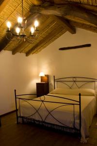 a bedroom with a bed and a chandelier at B&B Charme Sa Pardina in Orroli