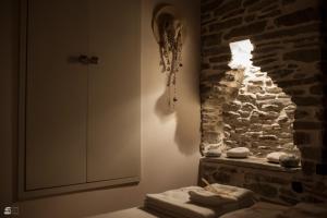 a bathroom with a stone wall and a stack of towels at Stone Villa Pelion in Afissos +48 photos