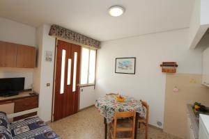 ビビオーネにあるPina e Carlettoのテーブル付きの部屋、窓付きのキッチンが備わる客室です。