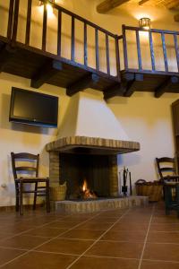 a living room with a fireplace and a staircase at B&B Charme Sa Pardina in Orroli