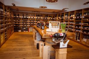 ein Weinprobenraum mit Theke und Regalen voller Weinflaschen in der Unterkunft Hotel Weinstube in Nendeln