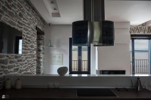 a kitchen with two windows and a stone wall at Stone Villa Pelion in Afissos