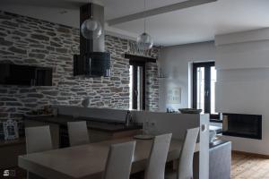 a kitchen with a table and chairs and a stone wall at Stone Villa Pelion in Afissos