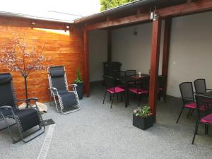 a patio with black chairs and tables and a wooden wall at Apartmány Cechovní in Moravská Třebová