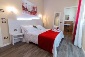 um quarto com uma cama branca e um cobertor vermelho em Venice Airport Villa Erica em Campalto