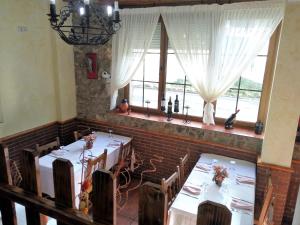 a dining room with two tables and a window at Hotel Rural La Piedra in Arija