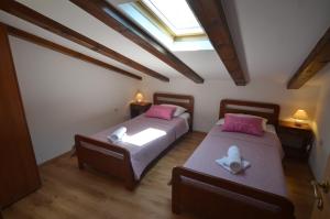 2 camas con almohadas rosas en una habitación en Apartment Casa Nova, en Rovinj