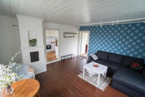 ein Wohnzimmer mit einem Sofa und einem Tisch in der Unterkunft Anfasteröd Gårdsvik - Sjöstugan in Ljungskile