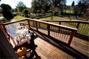a wooden deck with a bench and a fence at Pearlessence Vineyard Inn in Sebastopol