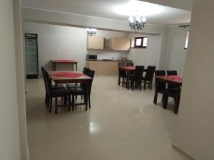 eine Küche und ein Esszimmer mit Tischen und Stühlen in der Unterkunft Vila Elva in Eforie Sud + 74 Fotos
