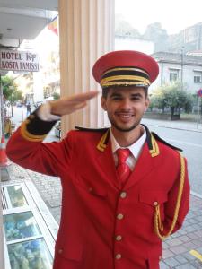 un hombre de uniforme rojo está sonriendo en Hotel Kosta Famissi, en Kalambaka