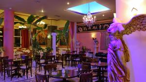 an angel statue in a restaurant with tables and chairs at Hotel Kosta Famissi in Kalabaka