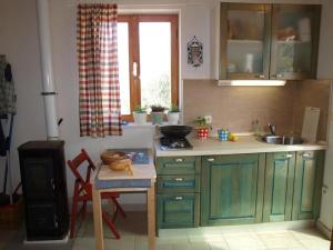 a kitchen with green cabinets and a table and a sink at Vacation Home Friday in Korčula