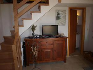 a television on a wooden dresser in a room with stairs at Vacation Home Friday in Korčula