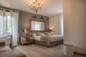 Dormitorio con cama con espejo y lámpara de araña en Albergo Diffuso Locanda Senio, en Palazzuolo sul Senio