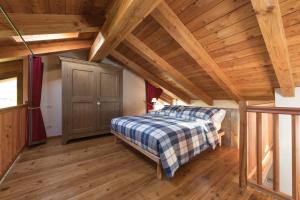 a bedroom with a bed and a wooden ceiling at L'Atelier du Temps - Le matin clair in Aosta