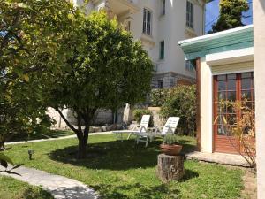 a garden with two chairs and a table and a tree at Villa Lorraine in Vence