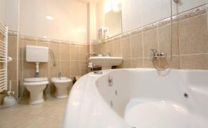 a bathroom with a tub and a toilet and a sink at Hotel Bosna 1 in Sarajevo