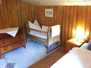 um quarto com paredes de madeira, uma cama e uma cómoda em Ferienhaus Sinz em Schwarzenberg im Bregenzerwald