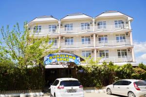 two cars parked in front of a building at Hotel Anapskiy Briz in Anapa