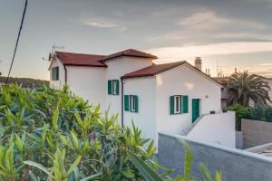 a white house with green shutters at Apartman Leon & rent a quad in Mali Lošinj