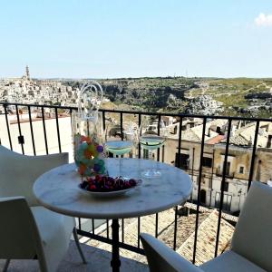 un tavolo con un cesto di frutta in cima a un balcone di Limen Matera Guesthouse a Matera