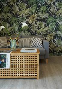 a living room with a couch and a table with a wallpaper at THE HABITAT Koh Chang in Ko Chang