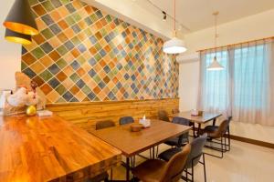 a dining room with tables and chairs and a mosaic wall at 木子屋民宿Lee House in Guanshan