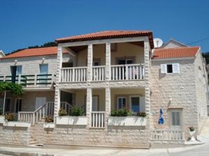 a stone house with a balcony on the side of it at Eni apartments BOL in Bol