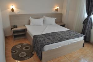 a small bedroom with a bed and a table at Hotel Regal in Eforie Nord +25 photos