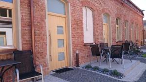 a group of chairs sitting outside of a brick building at Maison am Liesingbach in Vienna