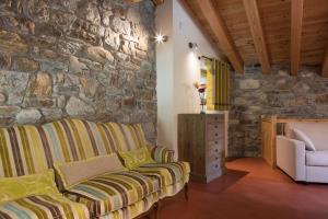 a living room with a couch and a stone wall at L'Atelier du Temps - Le matin clair in Aosta