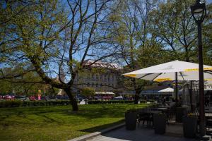 a park with tables and an umbrella and a building at Cathedral Sq. Apartment - Odminiu Str. in Vilnius