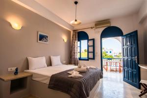 a bedroom with a bed and a large window at Katefiani Villas in Perissa