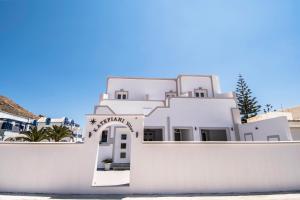 a white building with an arch in front of it at Katefiani Villas in Perissa