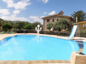 una gran piscina con un tobogán frente a una casa en Terrazze sul Tirreno, en Lascari