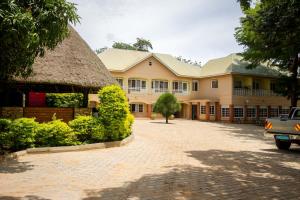 a large yellow building with a thatch roof at Jinja Safari Hotel in Jinja