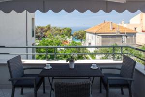 uma mesa numa varanda com vista para o oceano em Apartments Ivandić em Tučepi