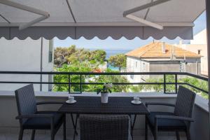 a table and chairs on a balcony with a view of the ocean at Apartments Ivandić in Tučepi