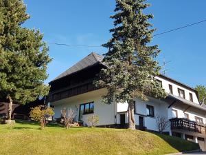 Una casa blanca con un árbol delante. en Gästehaus Bartlehof, en Schluchsee