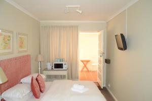 a hotel room with a bed and a television at The Winelands Guest House in Bellville