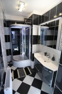 a bathroom with a black and white checkered floor at Centrum Lux Apartman in Kaposvár