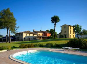 a large swimming pool in front of a house at Ca' Virginia Country House Wellness in Montecalvo in Foglia