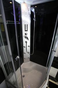 W łazience znajduje się prysznic ze szklanymi drzwiami. w obiekcie Centrum Lux Apartman w mieście Kaposvár +19 zdjęć