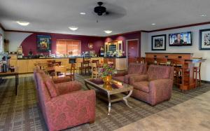 una sala de estar con sofás y mesas y un bar en Baymont by Wyndham Golden/Red Rocks, en Lakewood