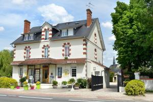 een groot wit gebouw aan de straatkant bij Logis Hôtels Restaurant Le Dauphin in Salbris